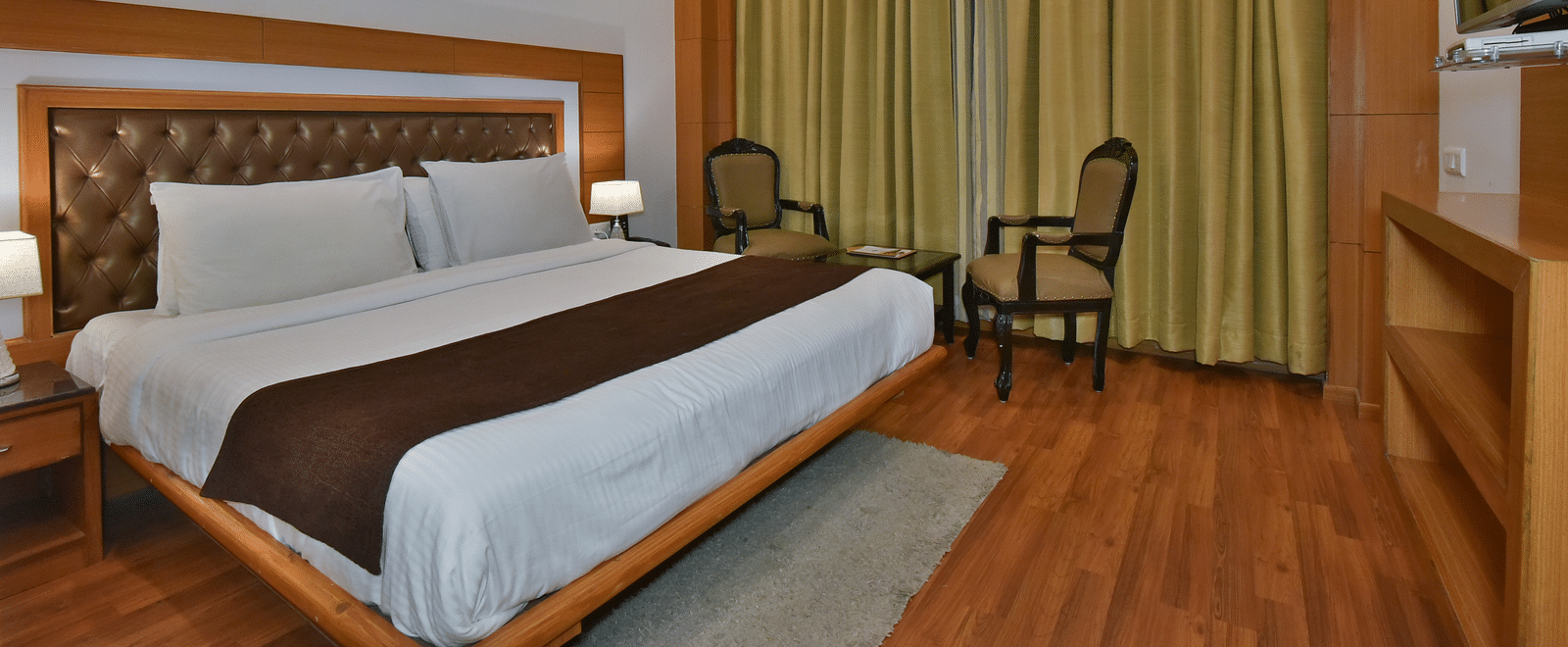 A large bed in Luxury Room Without Balcony at DLS Highland Resort and Spa, Mussoorie.
